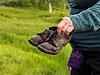 Nærbilde av en person som holder et par slitte sko