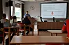 Møterom der en mann viser en presentasjon på et projektorlerret.