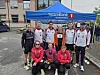 Seks personer poserer foran et blått SpareBank 1 Nordmøre-telt på en parkeringsplass.