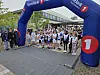 Gruppe løpere står samlet under en blå SpareBank 1-bue ved startområdet.