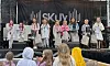 Flere personer står på en scene med premier foran publikum.