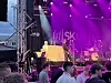 Band opptrer på utendørsscene med lilla lys og SKI-logo i bakgrunnen.