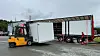 Gaffeltruck ved en semitrailer med åpen side på et industrilagerområde.