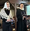 To personer står foran i et kirkerom under en seremoni.