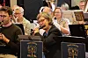 Musikere spiller i et orkesterrom med noter og instrumentstativer.