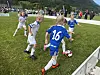 Unge fotballspillere kjemper om ballen nær cornerflagget på en gressbane.