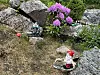 Steiner, blomster, busker og små dekorfigurer.