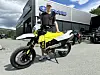 Gul og hvit motorsykkel foran en Polaris-butikk, med en person ved siden av.