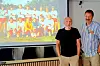Henne og Rolf Ole Kvernberg med Troll-laget på skjermen bak.