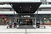 Overbygget inngang til Metro Shopping Center i Lørenskog med benker foran.