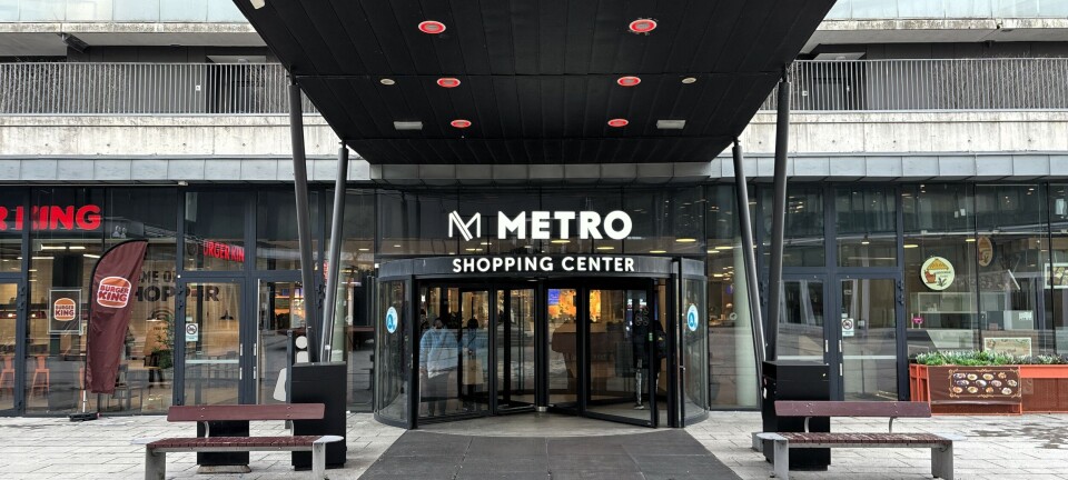 Overbygget inngang til Metro Shopping Center i Lørenskog med benker foran.