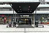 Overbygget inngang til Metro Shopping Center i Lørenskog med benker foran.
