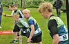 Unge løpere med startnummer står på rekke før start.