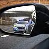 Politibil med blålys speilet i et bilspeil på motorvei.