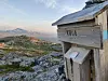 Trekasse merket «URA» ved en steinete fjellrygg med utsikt mot fjellandskap.