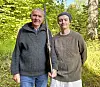 To menn står side om side i skogen, den ene med en rifle i hånden.
