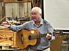 Mann som spiller akustisk gitar og snakker.