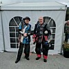 To konkurranseskyttere står foran et hvitt telt på grusunderlag.