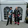 To konkurranseskyttere står foran et hvitt telt på grusunderlag.