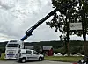 Kranbil heiser opp et festivalskilt ved veien i Rindal.