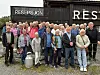 En stor gruppe mennesker står samlet foran en bygning med skiltet Resepsjon.