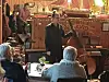Et band spiller live i en restaurant, med gjester ved bordene i forgrunnen.