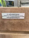 Skilt festet på en trebenk med tekst om en velfortjent pause.