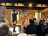 To utøvere står foran publikum i en trelåve, én seg for nesa og én holder en gitar.