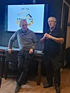 To menn står foran en presentasjonsskjerm i et mørkt lokale.