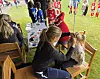Voksen ordner håret til et barn ved sidelinjen under en fotballturnering.