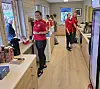 Flere personer står inne på et kjøkken i et klubbhus.