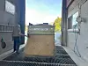 Korn som tømmes av en lys grønn henger.