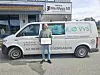 Mann med innrammet dokument foran en varebil merket Miljø VVS.