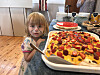Barn ved siden av en stor hjemmelaget kake med norske flagg.