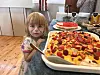 Barn ved siden av en stor hjemmelaget kake med norske flagg.