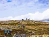 En gruppe turgåere på en steinete fjellrygg under en skyet himmel.
