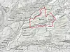 Grått topografisk kart med et uregelmessig område markert med rød linje.