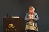 Lina Mogstad står ved en talerstol og presenterer foran en mørk bakgrunn.
