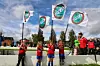 Fire unge fotballspillere i røde trøyer holder hvert sitt øsil-flagg som vaier i vinden.