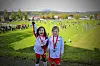 To barn med medaljer står på en gressbane under en fotballturnering.