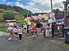 Deltakere løper under en portal av fargerike ballonger ved et utendørs arrangement.
