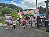 Deltakere løper under en portal av fargerike ballonger ved et utendørs arrangement.