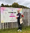 Løper med startnummer står foran et banner for Vi bryr oss-løpet.