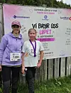 To løpsdeltakere foran et banner for Vi bryr oss-løpet.