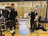 To personer står på en Pipelife-stand i en idrettshall.