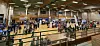 Folk samles rundt en sportsbane i en stor innendørshall.