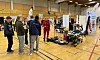 Messe i idrettshall med besøkende, utstillere og elektriske hjelpemidler.