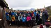 Turgruppe poserer foran en hytte med fjell og høstlandskap i bakgrunnen.