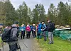 Ei gruppe turgåere på grusvei i skogen, med en person med ryggsekk i forgrunnen.