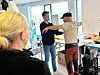 To personer øver sammen i et lyst rom, mens en tredje person står i forgrunnen.